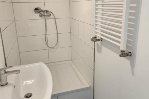 a white bathroom with a shower and a sink at Work & Stay Apartments in Stolberg in Stolberg