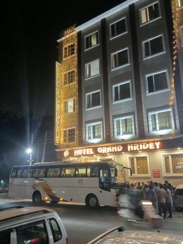 a bus parked in front of a hotel at night at Grand Hridey 1 minute from Railway Station in Amritsar