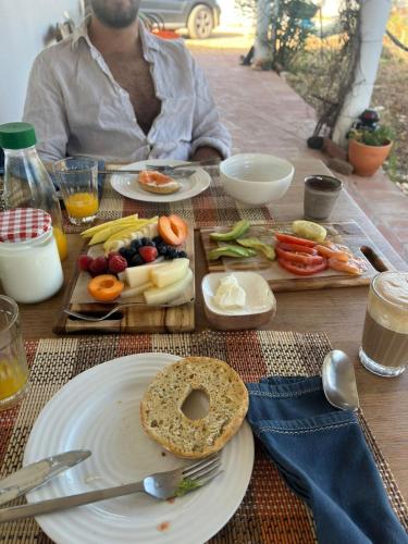a man sitting at a table with a plate of food at casa paz tavira in Tavira
