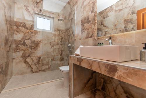 Villa Erato Family في Mouzákion: حمام مع حوض ومرحاض