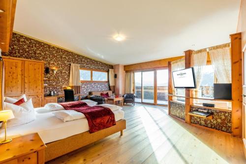 ein Schlafzimmer mit einem großen Bett und ein Wohnzimmer in der Unterkunft Wellness Aparthotel Panorama Alpin - Ferienwohnungen Jerzens im Pitztal in Jerzens