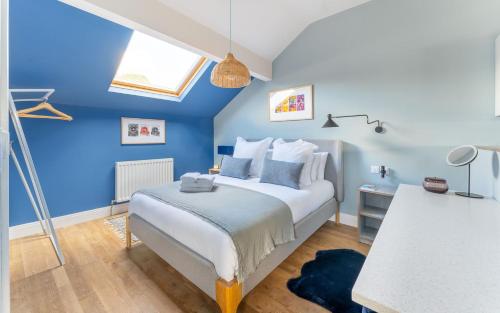 een slaapkamer met een bed met een blauwe muur bij Swallow in Bowness-on-Windermere