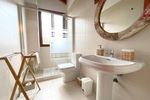a white bathroom with a sink and a mirror at Acogedor chalet adosado con entrada independiente in Lamadrid