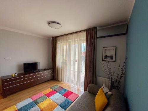 uma sala de estar com um sofá e uma televisão em Cherry Abode Apartment with Terrace em Budapeste