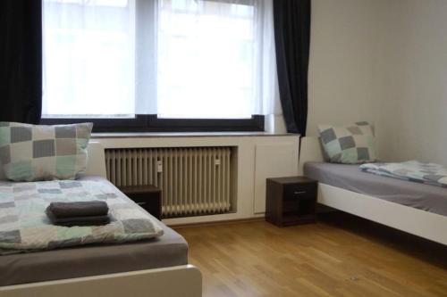 Schlafzimmer mit einem Bett und einem Fenster mit Vorhängen in der Unterkunft Maye Oberhausen City Deluxe 3 in Oberhausen