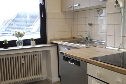 eine Küche mit einer Spüle und einem Heizkörper und einem Fenster in der Unterkunft Maye Oberhausen City Deluxe 3 in Oberhausen