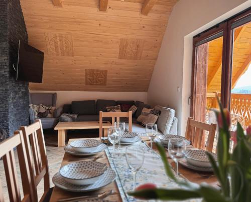 a dining room with a table and a couch at Apartamenty na Soszowie, Wisła - widokowe miejsce z Balią & Prywatną Sauną, obok stoku narciarskiego i Bike Parku, dla max 16 osób in Wisła