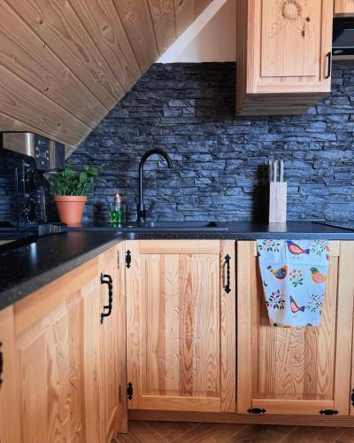 a kitchen with wooden cabinets and a sink at Apartamenty na Soszowie, Wisła - widokowe miejsce z Balią & Prywatną Sauną, obok stoku narciarskiego i Bike Parku, dla max 16 osób in Wisła
