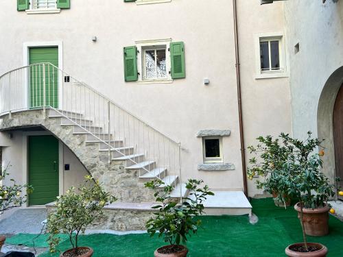 uma escada num edifício com portas verdes e plantas em Studios Al Castello dei Limoni em Limone sul Garda