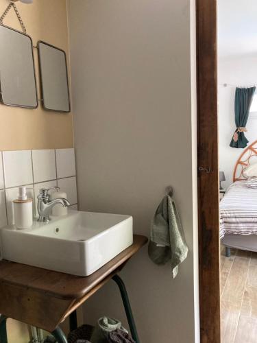 y baño con lavabo sobre una mesa de madera. en Maison d hôtes LA VILLA MADELEINE en Sanary-sur-Mer