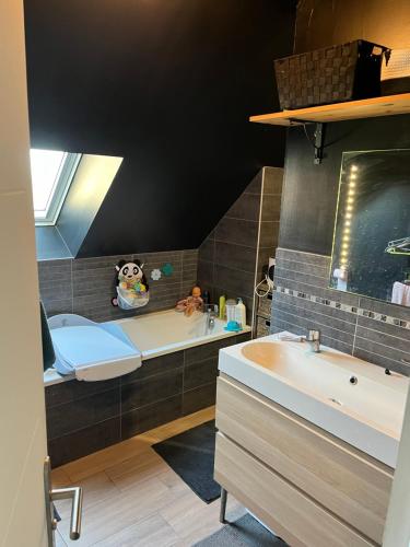 La salle de bains est pourvue d'une baignoire et d'un lavabo. dans l'établissement Maison pour 4 personnes proche Caen et mer, à Saint-Manvieu