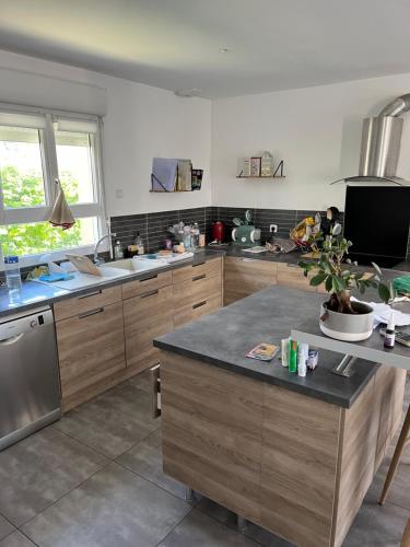 een keuken met houten kasten en een aanrecht bij Maison pour 4 personnes proche Caen et mer in Saint-Manvieu