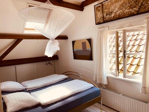 a small room with a bed and a window at Vakantie appartement Goedereede let op de badkamer moet met andere gasten gedeeld worden in Goedereede