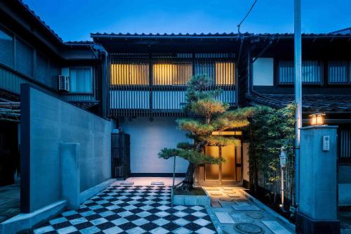 a house with a tree in the middle of a courtyard at Matsunoma Machiya House in Kanazawa