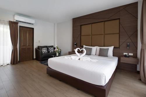 a bedroom with a large bed with a swan on it at The Bell Airport Phuket Hotel - SHA Extra Plus in Nai Yang Beach