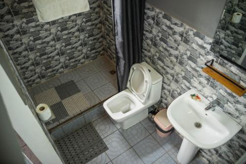 łazienka z toaletą i umywalką w obiekcie Come IN Hôtel w mieście Imerintsiatosika