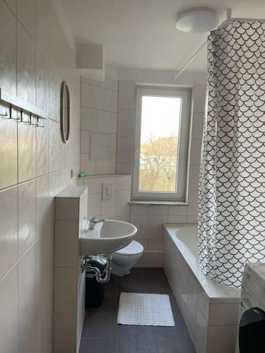 een badkamer met een wastafel, een toilet en een bad bij Monteurwohnung mit 5 Einzelbetten in Bitterfeld in Große Mühle