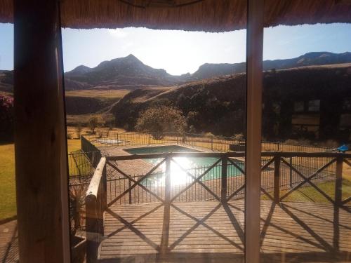 a window with a view of a pool and mountains at Ledges Retreat in Bergville