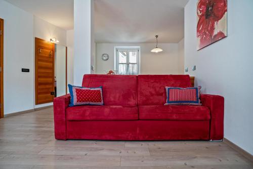 a red couch with two pillows on it in a living room at Casa Batistei Ribes in Molveno
