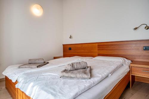 a large wooden bed with two pillows on it at Casa Batistei Ribes in Molveno