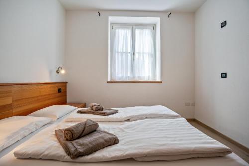 two beds in a room with towels on them at Casa Batistei Ribes in Molveno