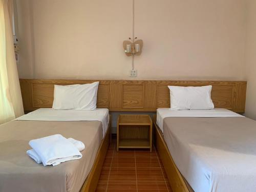 two beds sitting next to each other in a room at กิจตรงวิลล์ รีสอร์ท Kittrongvill in Ubon Ratchathani