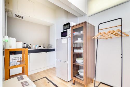 una cucina con armadietti bianchi e frigorifero di Family Inn Nara a Nara