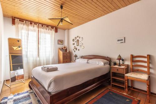 1 dormitorio con 1 cama grande y 1 silla en Ganburu apartment by People Rentals, en Bilbao