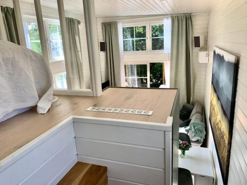 ein Schlafzimmer in einem winzigen Haus mit einem Bett und Fenstern in der Unterkunft Strandnära, pergola, P-plats, nära Eurovision in Höllviken
