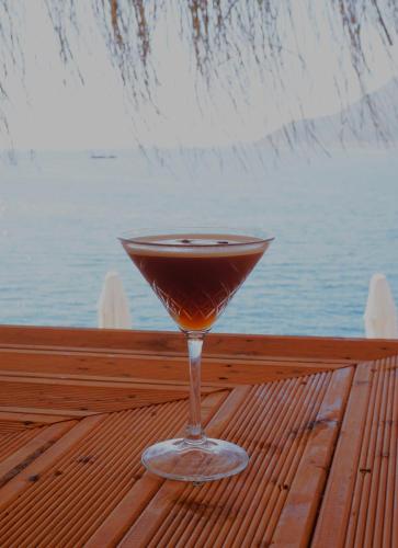a drink in a glass sitting on a table near the water at Mavilim Hotel in Kas