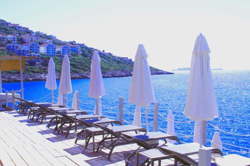 a row of chairs and umbrellas on a dock at Mavilim Hotel in Kas