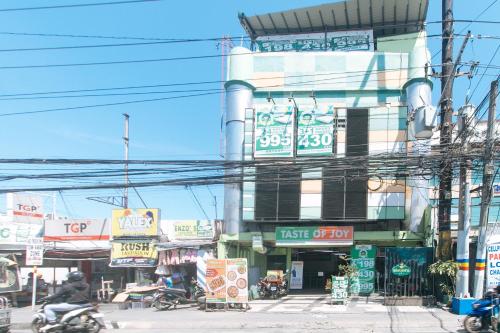 RedDoorz at Ranchotel Bayanan Alabang في مانيلا: مبنى عليه لافتات على جانب شارع