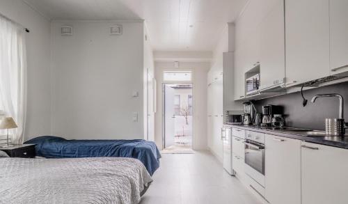 a room with two beds and a kitchen with a sink at Cozy apartment in Espoo