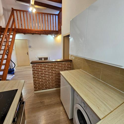 a kitchen with a washer and dryer and a staircase at Charmes & Confort hypercentre Verdun entre Montauban et Toulouse in Verdun-sur-Garonne