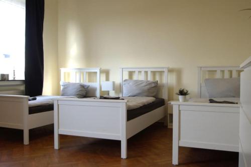 een slaapkamer met 2 witte bedden en een raam bij Ferienwohnung Maye Oberhausen in Oberhausen