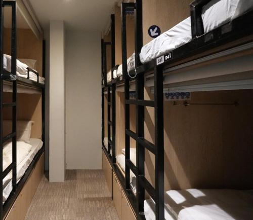 eine Reihe von Etagenbetten in einem Zimmer in der Unterkunft The Room @ Bugis in Singapur
