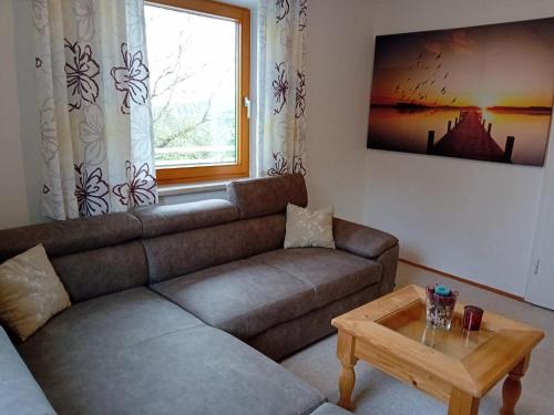 a living room with a couch and a table at Gasthof-Pension Zum Haugstein - Familie Eder in Engelhartszell