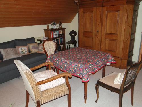 ein Wohnzimmer mit einem Tisch, Stühlen und einem Sofa in der Unterkunft Ferienwohnung Am Schlosspark in Schlitz