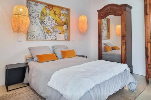 sypialnia z dużym białym łóżkiem i lustrem w obiekcie Maison T2 avec patio w La Rochelle
