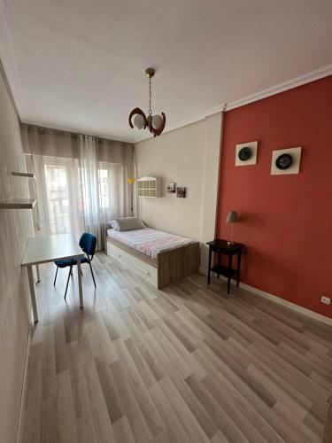 a bedroom with a bed and a table in a room at Apartamento en el Centro Histórico de Nájera in Nájera