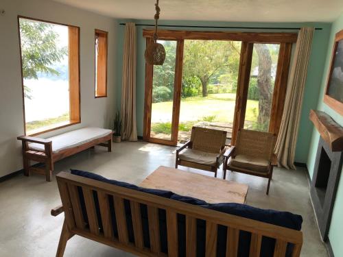 Baranko Villa في Fort Portal: غرفة معيشة مع أريكة وطاولة ونوافذ