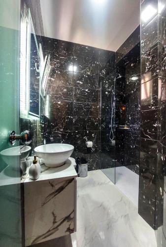 a bathroom with a sink and a glass shower at POLYMNIA III LUXURY APARTMENT ARGOSTOLI in Argostoli