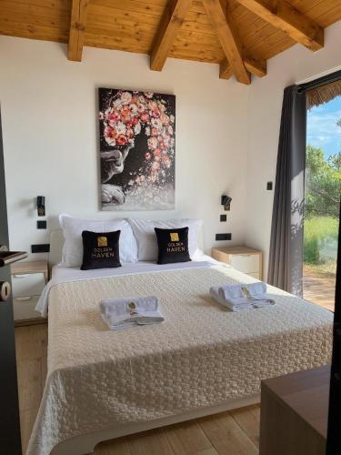 a bedroom with a bed with two towels on it at Golden Haven Luxe Bungalow Resort in Murter