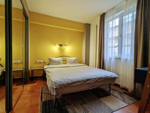 a bedroom with a bed and a large window at Peaceful Victory Square Home in Timişoara