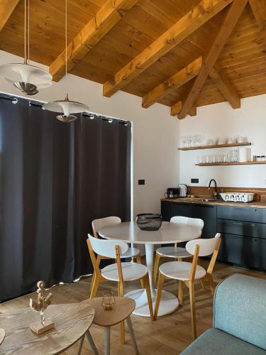 a dining room with a table and chairs and a kitchen at Golden Haven Luxe Bungalow Resort in Murter
