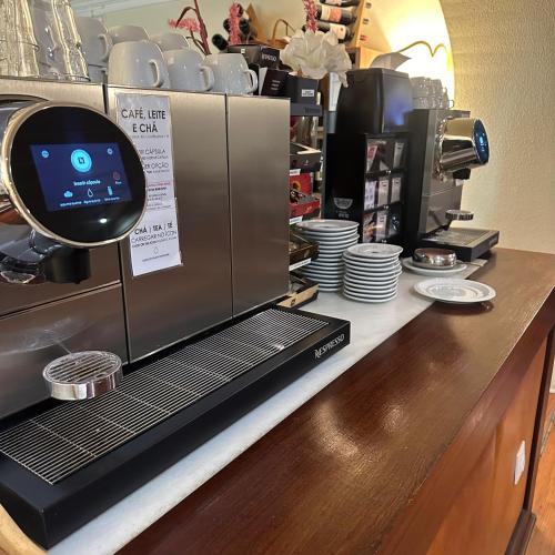 a counter with a coffee shop with a coffee machine at Hotel Joao Padeiro in Aveiro