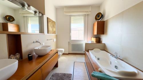 uma casa de banho com uma banheira, um lavatório e um WC. em Luxury Majestic Penthouse Apartment em Chioggia
