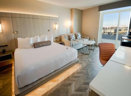a bedroom with a large white bed and a couch at Coast Victoria Hotel & Marina by APA in Victoria