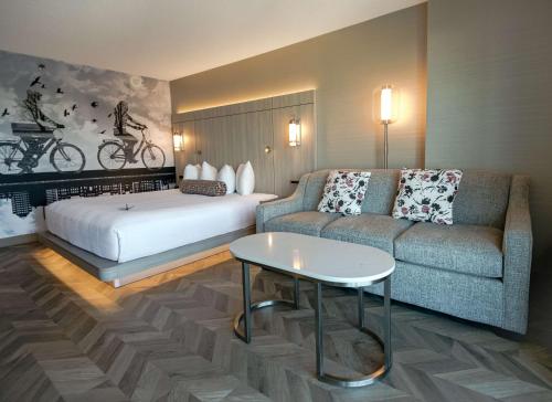 a hotel room with a bed and a couch at Coast Victoria Hotel & Marina by APA in Victoria