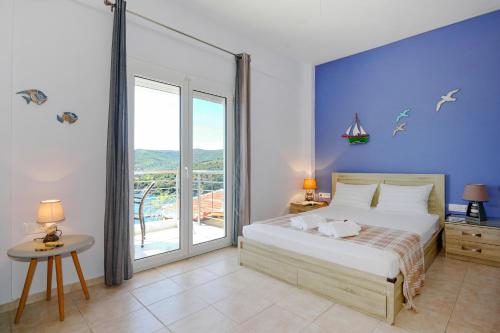 a bedroom with a large bed and a large window at Thea Studios in Pyrgadikia